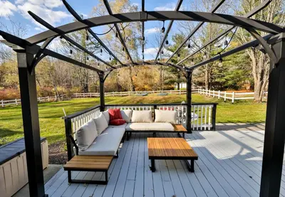 a pergola with a couch and tables on a deck at Mountain Dream Brand New Hot Tub Fire Pit in Hunter