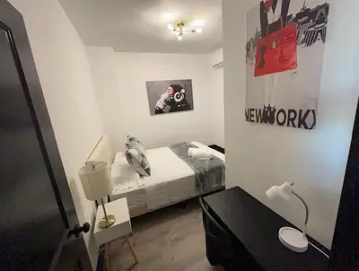 a small bedroom with a bed and a table at Apartment Few Minutes NYC and Prudential Center in Newark