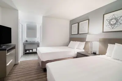 a hotel room with two beds and a flat screen tv at Hyatt House White Plains in White Plains