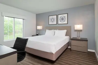 a bedroom with a large white bed and a chair at Hyatt House White Plains in White Plains