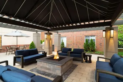 a patio with blue couches and a fire pit at Hyatt House White Plains in White Plains