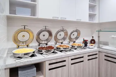 a kitchen with many bowls of food on a counter at Hyatt House White Plains in White Plains