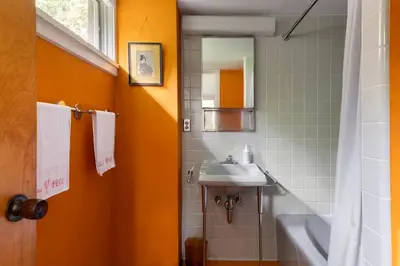 a bathroom with a sink and a mirror at Quarry House Mid-Century Modern in Haddam
