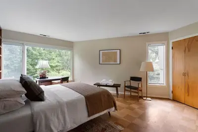 a bedroom with a large white bed and windows at Quarry House Mid-Century Modern in Haddam