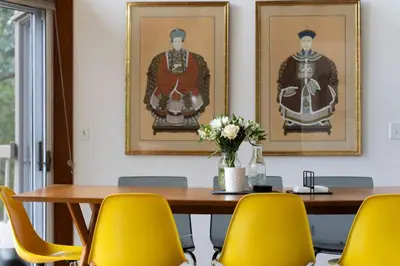 a dining room with a wooden table and yellow chairs at Quarry House Mid-Century Modern in Haddam