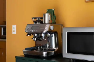 a coffee machine sitting on a counter next to a microwave at Quarry House Mid-Century Modern in Haddam