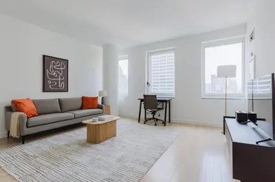 a living room with a couch and a table at Blueground Midtown gym wd ac nr Rock Ctr NYC-1536 in New York