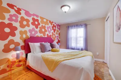 a bedroom with a bed with a flower patterned wall at 3BD Stevens Universe Theme - Games - Backyard in Tobyhanna
