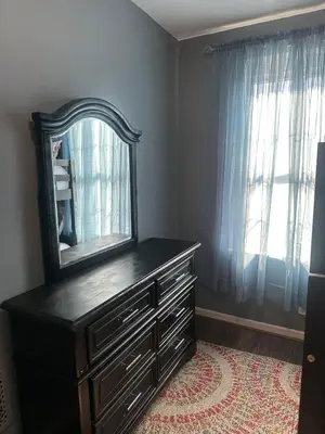a dresser with a mirror on top of it at Genevieves lovely suite in Jersey City