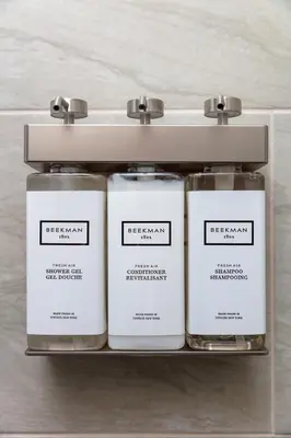 a row of three white candles on a shelf at Pelham Haven Suite in New York in Pelham