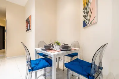 a dining room with a white table and blue chairs at 4 Bedroom Paradise next to Central Park in New York