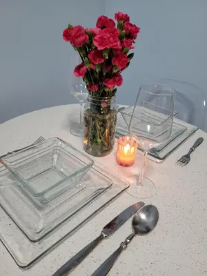 a table with a vase of red roses and a candle at Private Studio Near Columbia Presbyterian Hospital in New York
