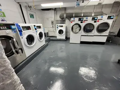 three washing machines and washers in a laundry room at Private Studio Near Columbia Presbyterian Hospital in New York