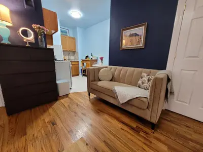 a living room with a couch and a kitchen at Private Studio Near Columbia Presbyterian Hospital in New York