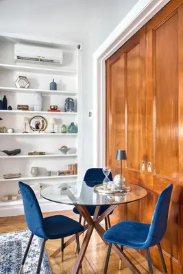 a dining room with a glass table and blue chairs at Hudson Navigator in Hudson