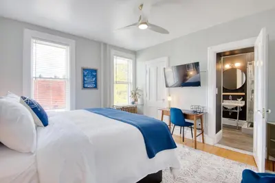 a white bedroom with a bed and a desk at Hudson Navigator in Hudson