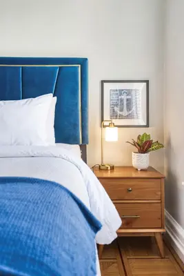 a bedroom with a blue bed and a wooden dresser at Hudson Navigator in Hudson