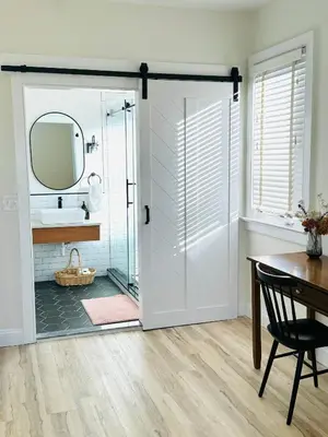 a bathroom with a glass door with a sink and a mirror at Designer cozy 1 private bedroom w full bath & yard 20 min to nyc in Harrison