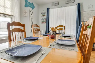 a dining room table with plates and silverware on it at Beachfront, Dog-Friendly Milford Getaway with Yard! in Milford