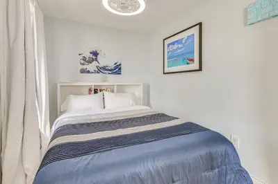 a white bedroom with a bed with a blue blanket at Beachfront, Dog-Friendly Milford Getaway with Yard! in Milford