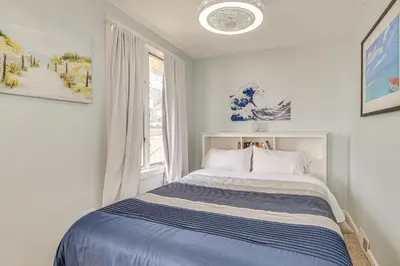 a bedroom with a bed with a blue and white striped blanket at Beachfront, Dog-Friendly Milford Getaway with Yard! in Milford