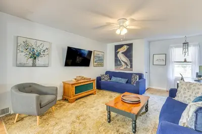 a living room with a blue couch and a tv at Beachfront, Dog-Friendly Milford Getaway with Yard! in Milford