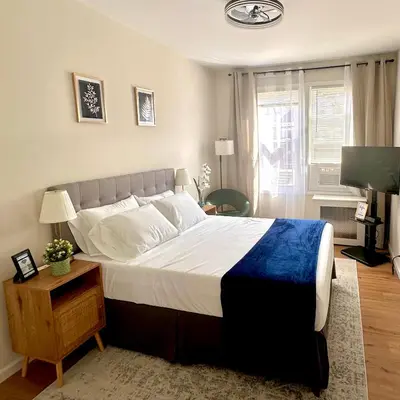 a bedroom with a large bed with a blue blanket at Newly Renovated 1 Bedroom Executive Apartment in Kearny