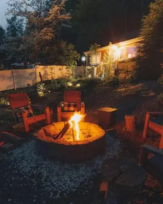 a fire pit in a yard at night at The Little Lake Cabin in New Fairfield