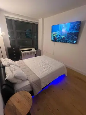 a bedroom with a bed in a room with a window at Beautiful 1 Bedroom Condo in Mott Haven