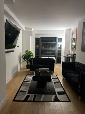 a living room with a couch and a table at Beautiful 1 Bedroom Condo in Mott Haven