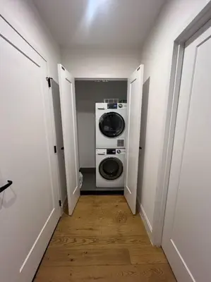 a hallway with a washer and dryer in a room at Beautiful 1 Bedroom Condo in Mott Haven