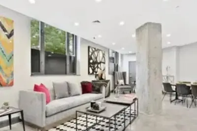 a living room with a couch and a table at Beautiful 1 Bedroom Condo in Mott Haven