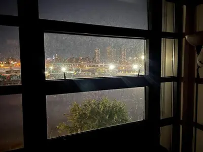 a window with a view of a city in the rain at Beautiful 1 Bedroom Condo in Mott Haven