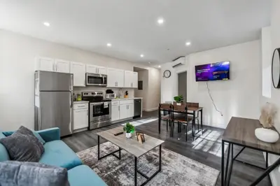 a living room with a blue couch and a kitchen at Washington Lofts 109 Spacious 1 Bedroom 1 Bath in Albany