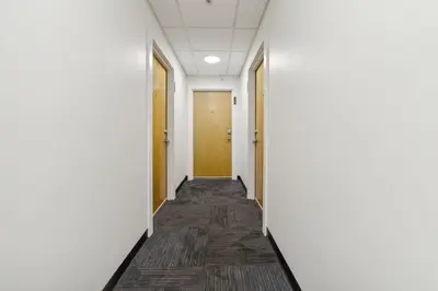 a corridor of an office with white walls and wooden doors at Washington Lofts 109 Spacious 1 Bedroom 1 Bath in Albany