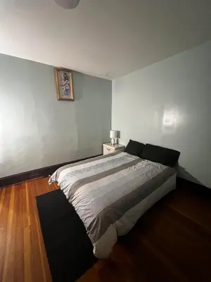 a bedroom with a bed and a table with a lamp at Holyoke House Oasis - Fast Wifi, Spacious, Quiet Neighborhood in Holyoke