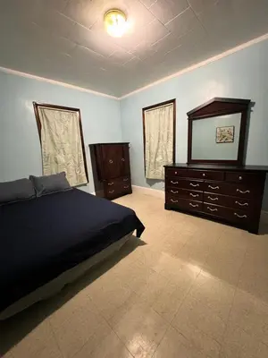 a bedroom with a bed and a dresser and a mirror at Holyoke House Oasis - Fast Wifi, Spacious, Quiet Neighborhood in Holyoke