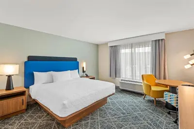 a hotel room with a bed and a desk at Hampton Inn Cooperstown in Cooperstown