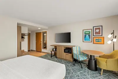 a hotel room with a bed and a desk and a tv at Hampton Inn Cooperstown in Cooperstown
