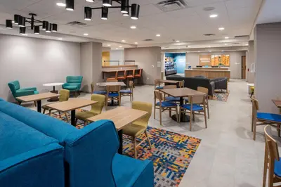 a waiting room with blue furniture and tables at Hampton Inn Cooperstown in Cooperstown