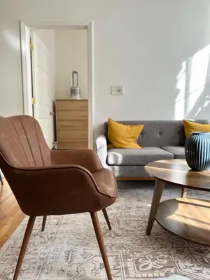 a living room with a couch and a chair at Cottage 215 Apartments in New York