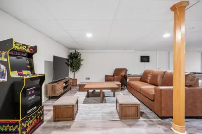 a living room with a couch and a video game at The Hera Haven - Pickleball, hot tub, racetrack & lake in Stillwater