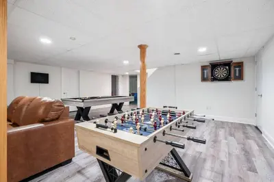 a living room with a foosball table and a couch at The Hera Haven - Pickleball, hot tub, racetrack & lake in Stillwater