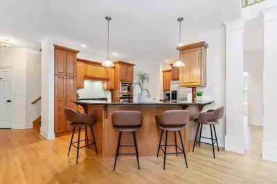 a kitchen with a island with bar stools at The Hera Haven - Pickleball, hot tub, racetrack & lake in Stillwater