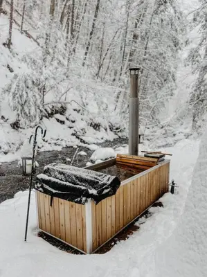a wooden hot tub with snow on top of it at Creek Side Cabin with Wood Fired Hot Tub and Fire Pit in New Milford