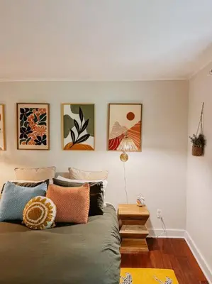 a living room with a couch and paintings on the wall at Creek Side Cabin with Wood Fired Hot Tub and Fire Pit in New Milford