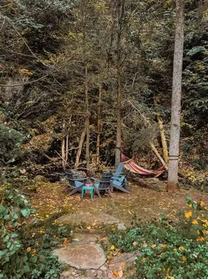 two chairs and a hammock in the woods at Creek Side Cabin with Wood Fired Hot Tub and Fire Pit in New Milford
