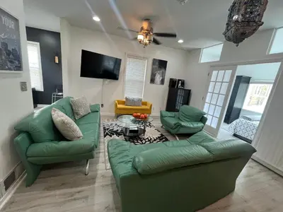 a living room with two green couches and a table at Spacious 3 bedroom close to NYC in North Bergen