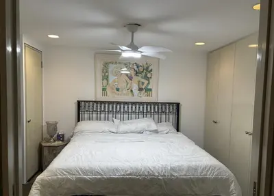 a bedroom with a bed with a ceiling fan at Cozy and Comfy Cellar in Yonkers