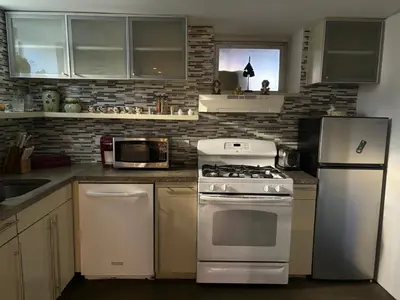 a kitchen with a white stove and a microwave at Cozy and Comfy Cellar in Yonkers